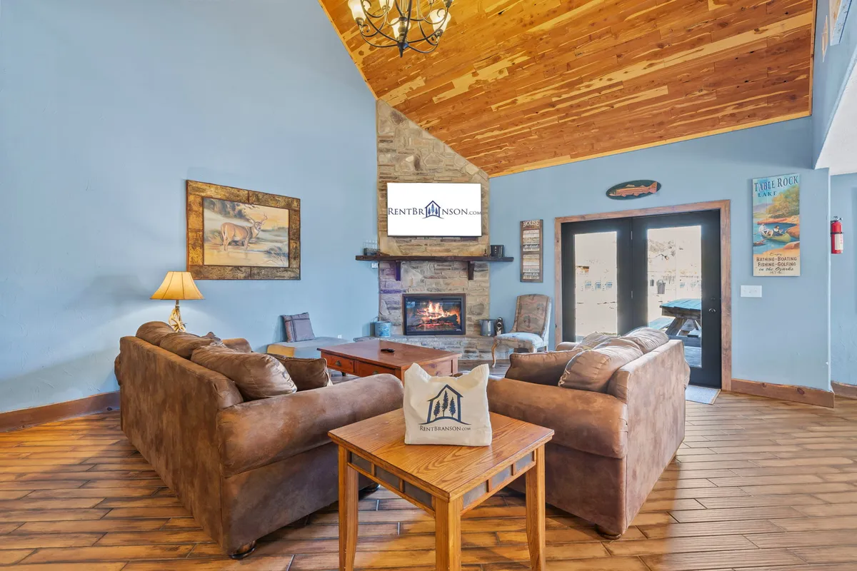 A cozy living room setup featuring plush sofas, a fireplace, a TV, a coffee table, and stylish artwork on the walls. The ambiance is relaxed and inviting, perfect for unwinding with family or friends.
